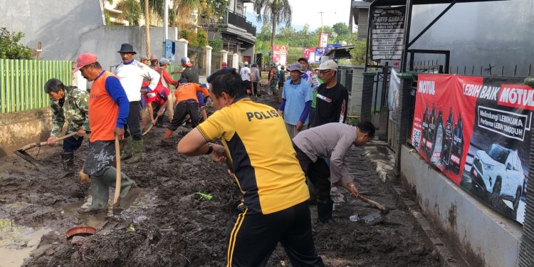 Sinergitas Polres Batu Bersama TNI dan Warga Bersihkan Lumpur Akibat Banjir Lalulintas Kembali Lancar