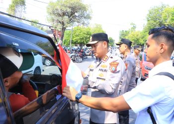 Kapolres Ngawi Turut Pasangkan Bendera Merah Putih di Kendaraan yang Melintas, Tingkatkan Jiwa Nasionalis